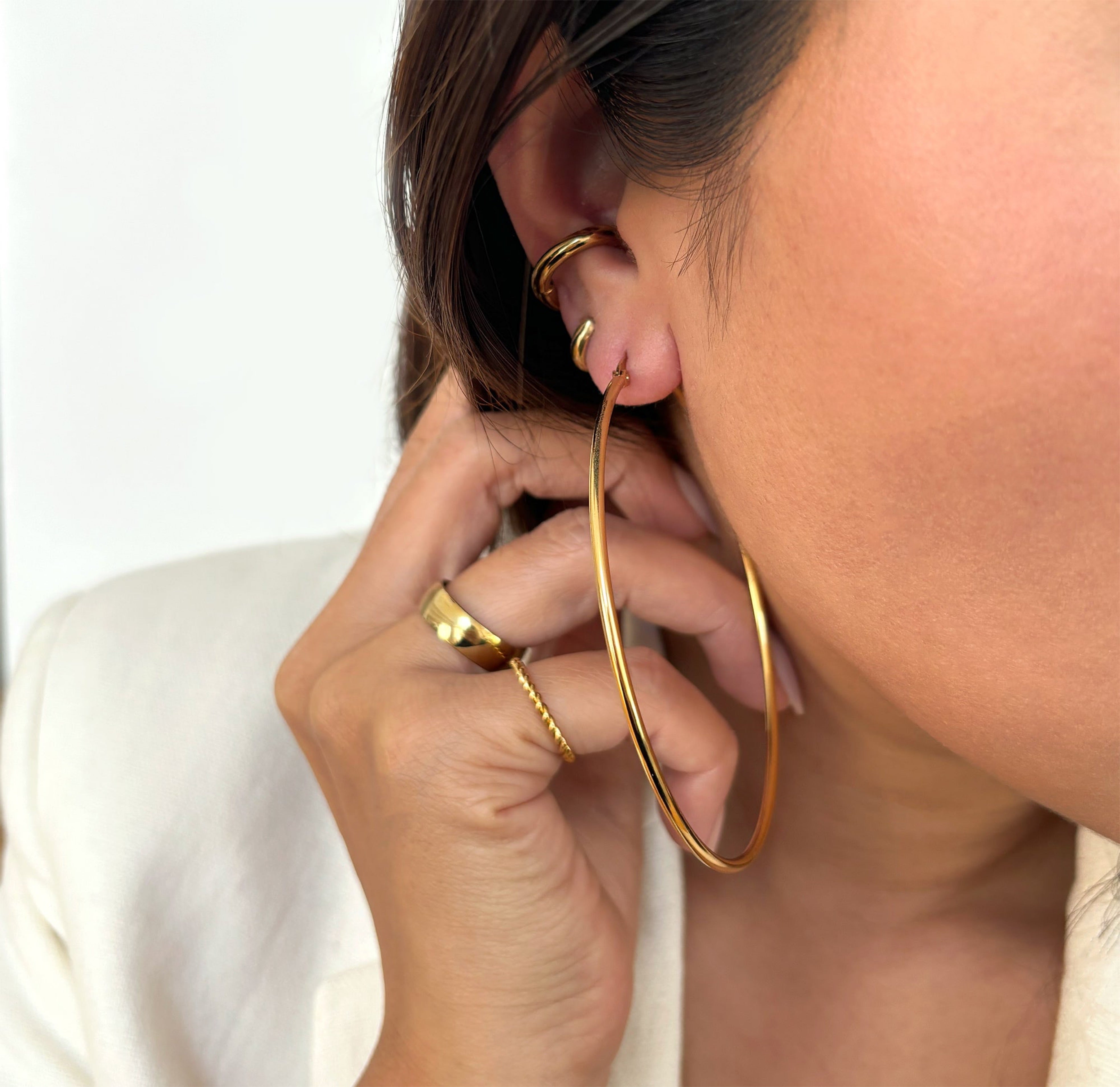 big gold thin hoop earrings worn on model waterproof jewelry