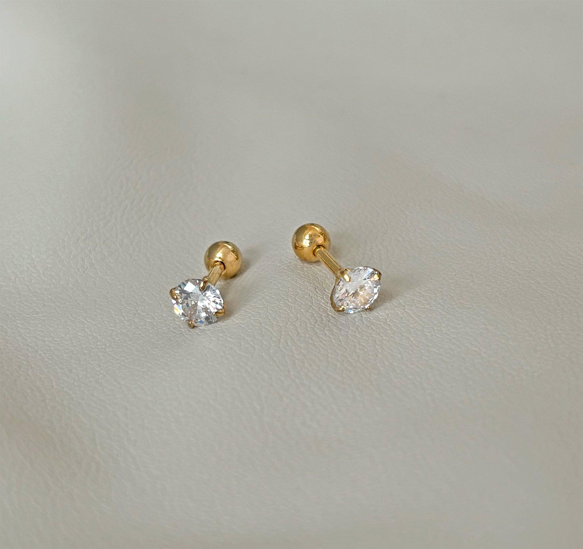 a pair of 3mm cubic zirconia gold stud earrings that have a screw back and is comfort fit