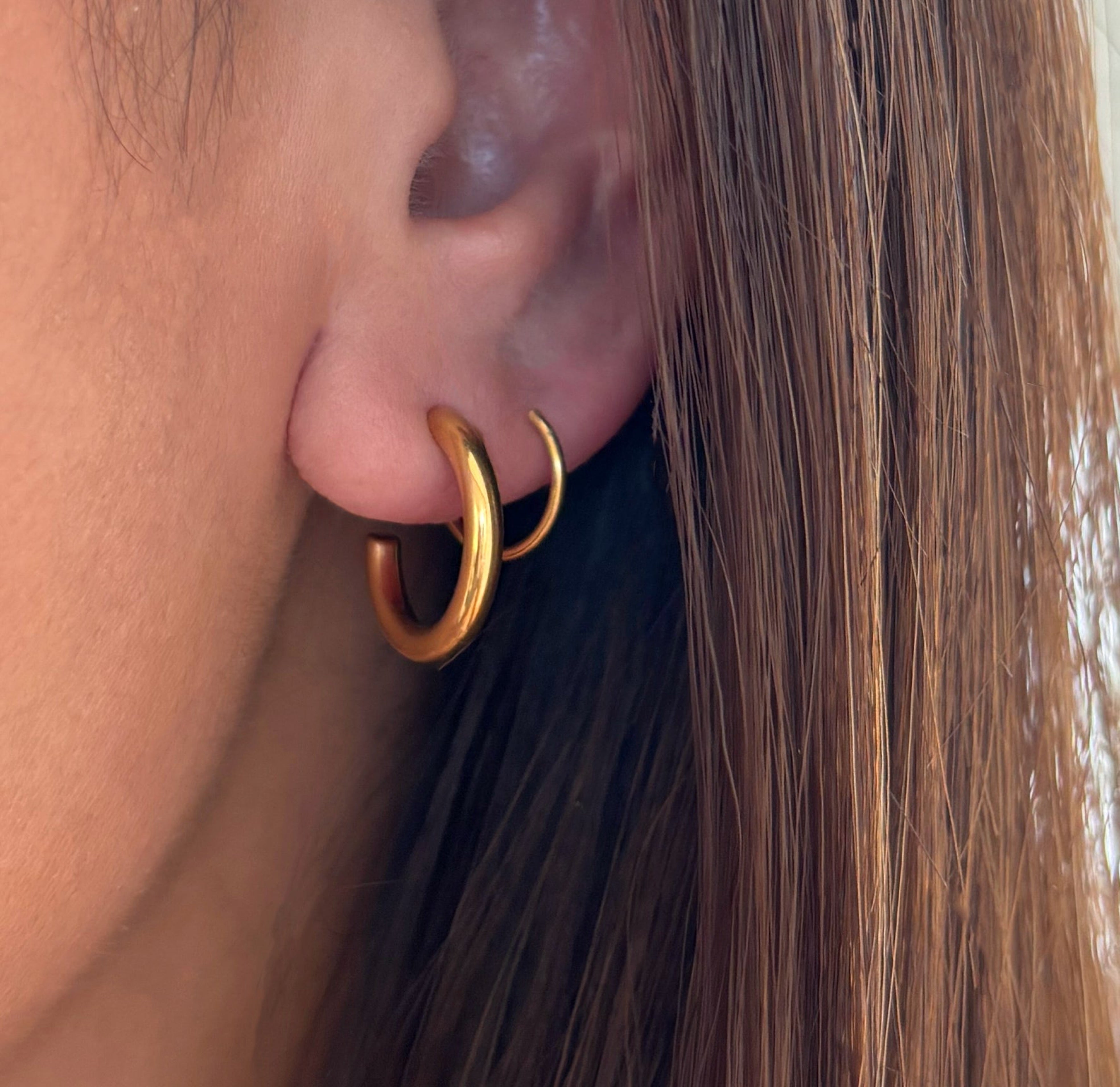 gold duo huggie hoop earrings worn on model