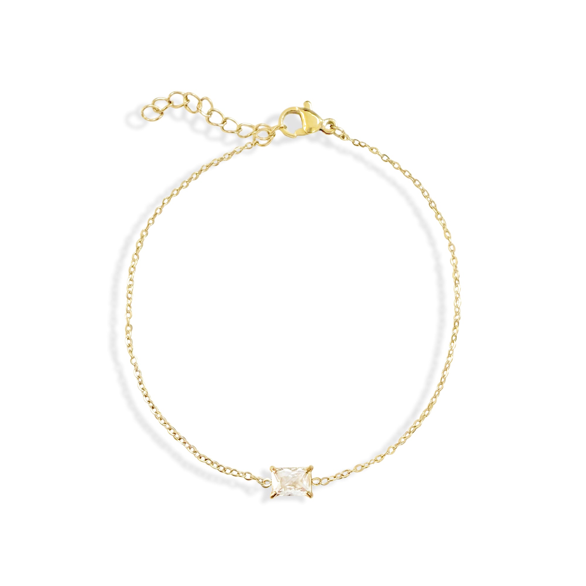 Gold bracelet with a clear gemstone on a white background