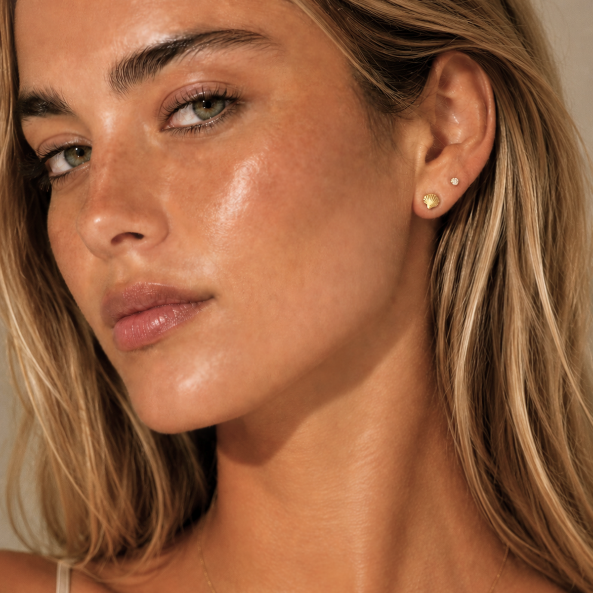 gold dainty seashell earring on model