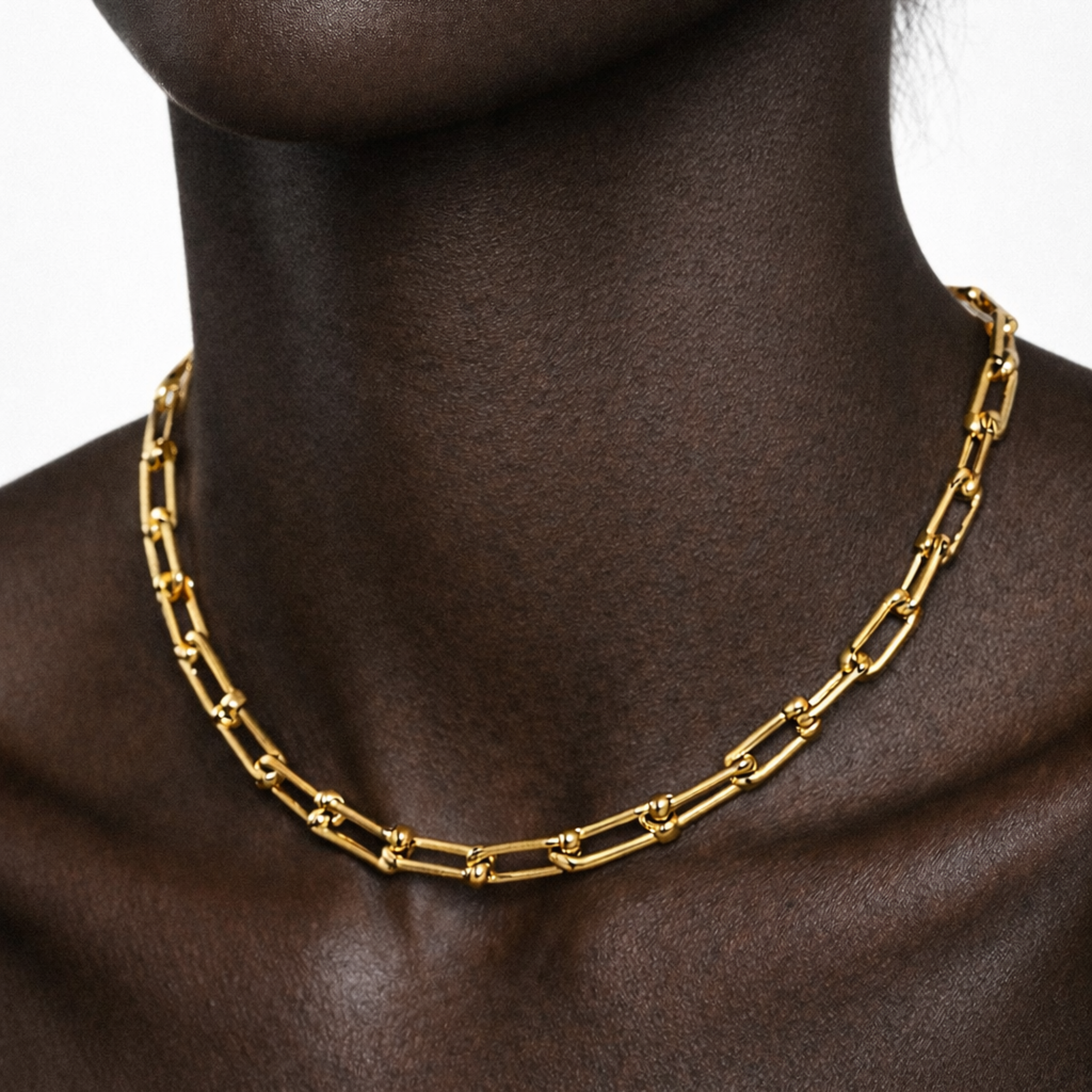 Gold chain necklace on a model with a white background