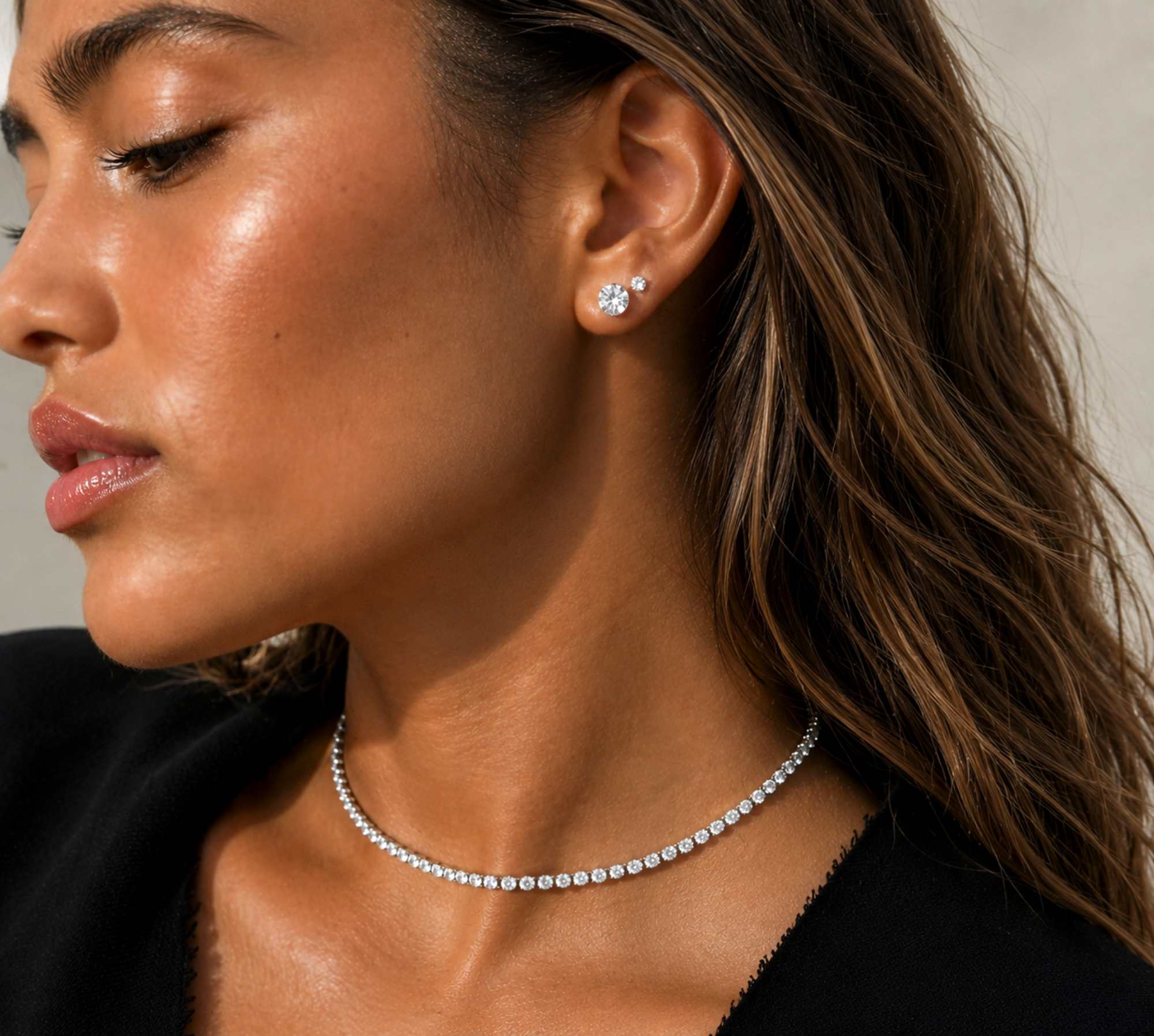 model wearing silver 2ct earrings stacked with a smaller diamond