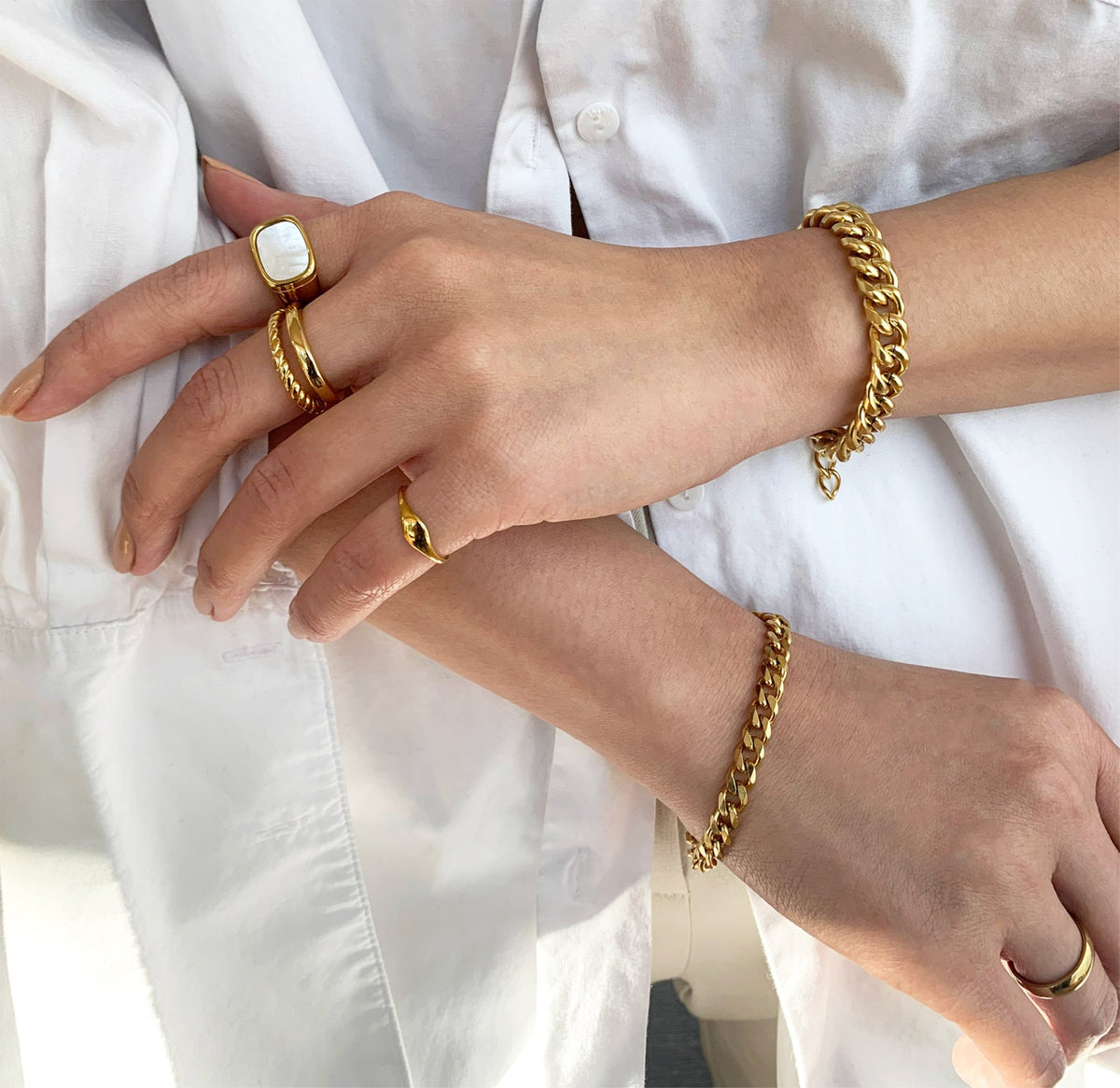Drew dainty gold signet pink ring paired with the gold square pear signet ring and Birdy gold duo ring worn on model, waterproof rings