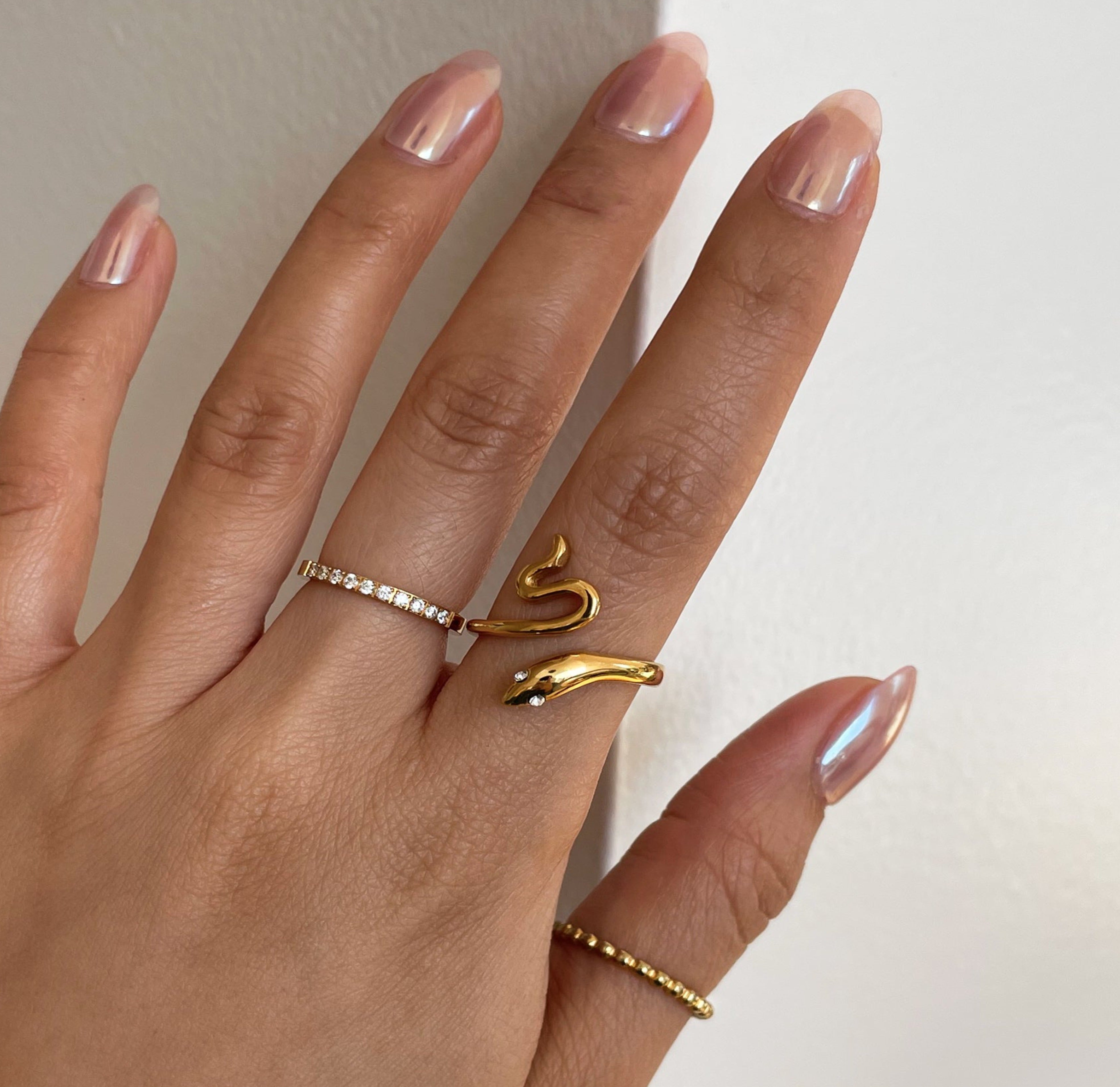 Jaina thin gold beaded ring paired with Stella gold hand eternity ring and Solange gold snake ring worn on model. Waterproof jewelry