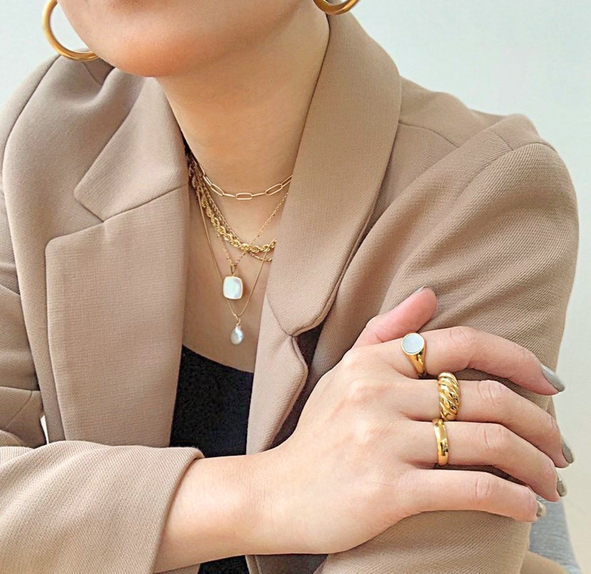 Gold Carson ring, classic medium ring band with high polish finish and comfort fit worn on model with Margaux gold croissant ring and Demi gold round pearl signet ring. Waterproof Jewelry