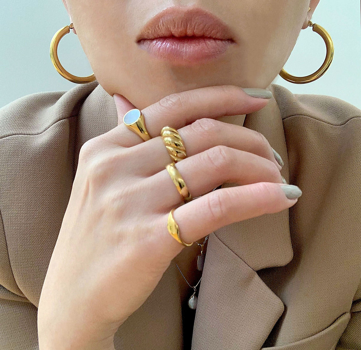 Carson clasic medium gold ring band worn on model with drew pike signet ring, gold Margaux croissant ring, and gold Demi round pearl sight ring. Waterproof jewelry