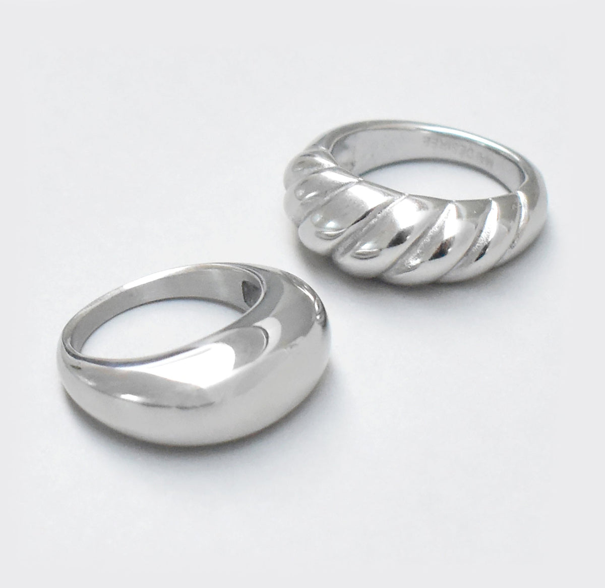 silver dome ring displayed with the silver argue croissant ring. waterproof jewelry