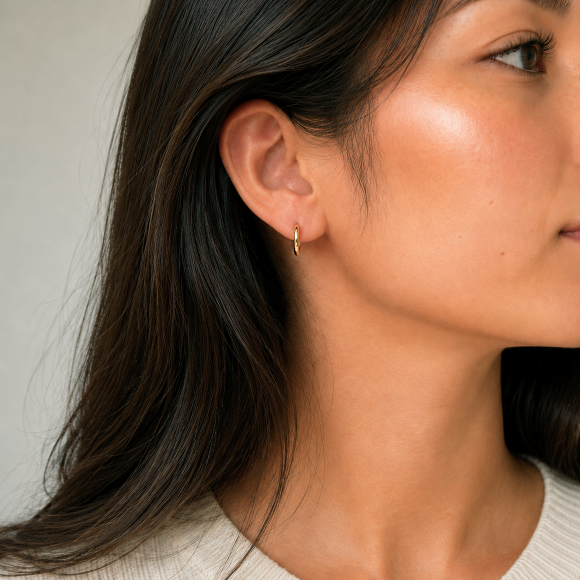 dainty 8mm gold huggie hoop earrings on model