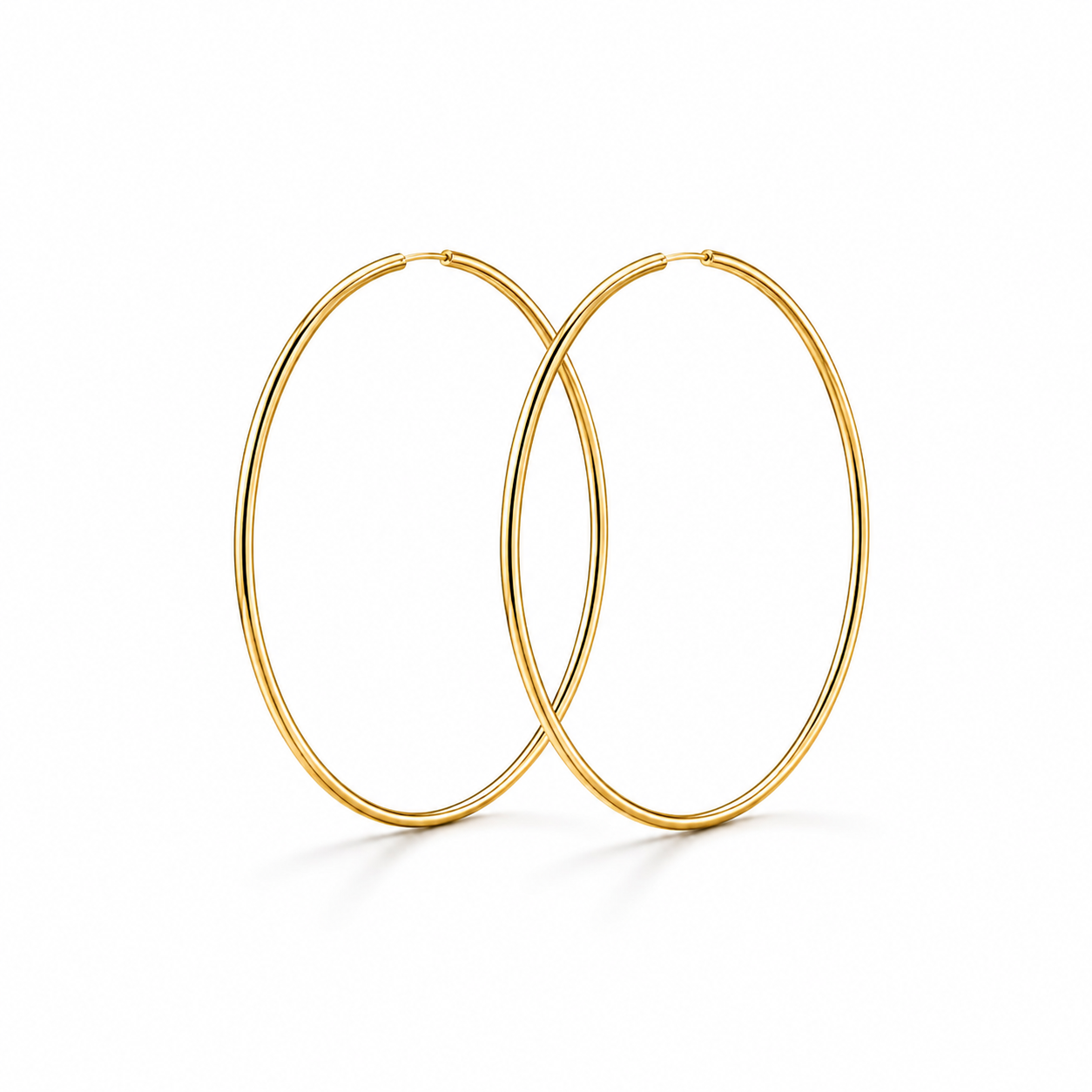 A pair of gold hoop earrings with a polished finish, shown overlapping on a clean white background.