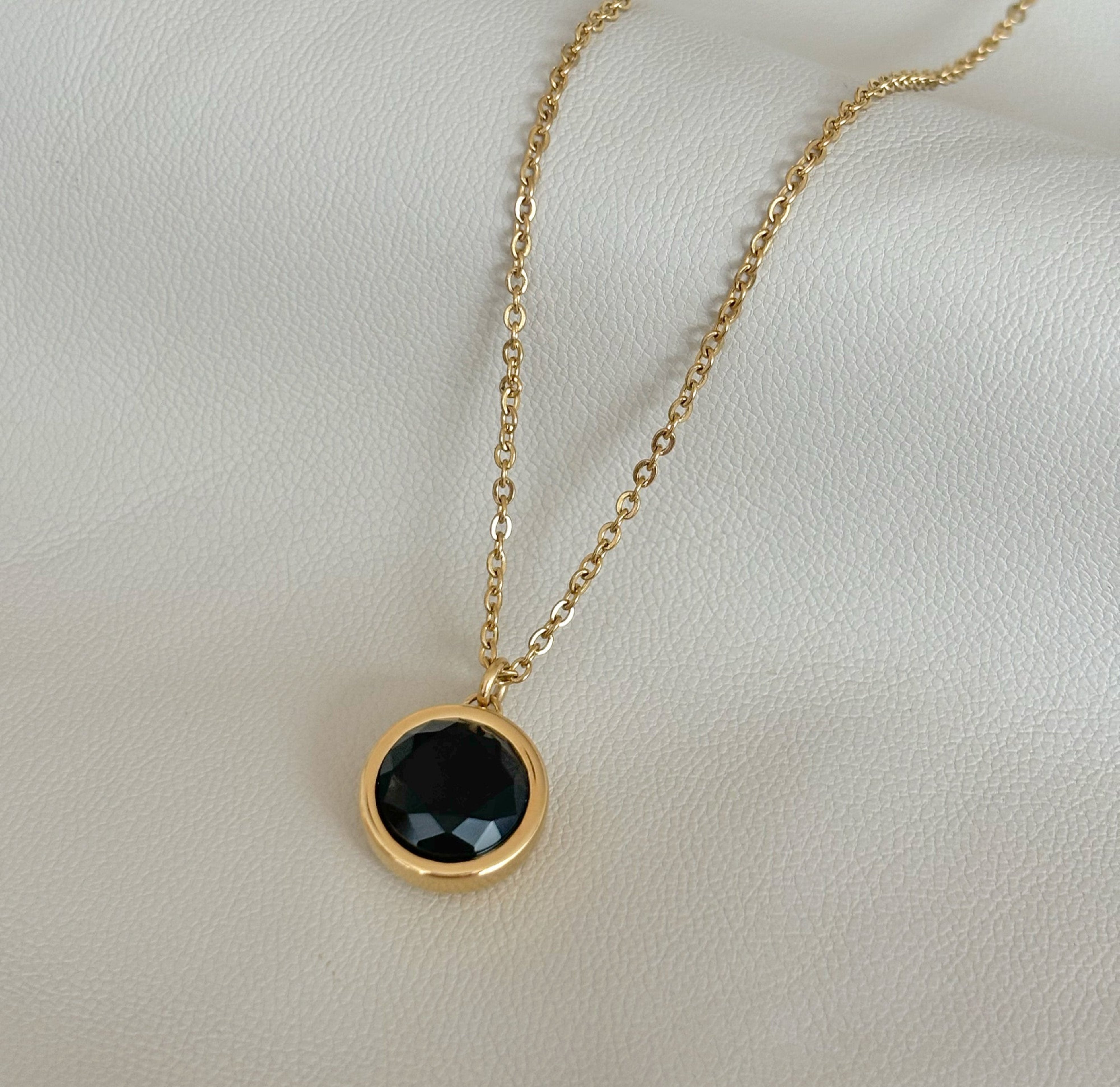 black round pendant necklace waterproof jewelry flat lay