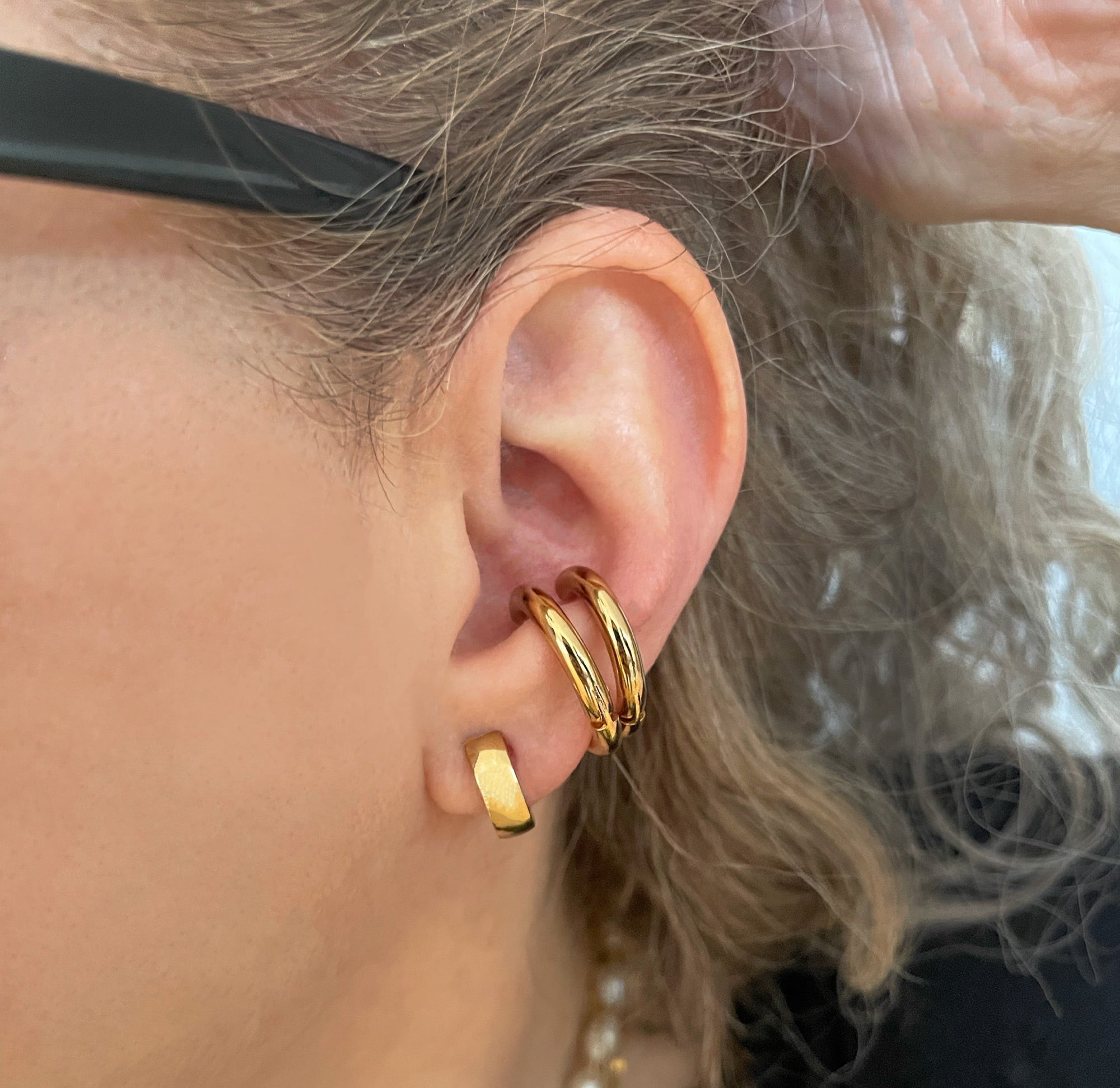 gold huggie hoop earrings worn on model waterproof jewelry