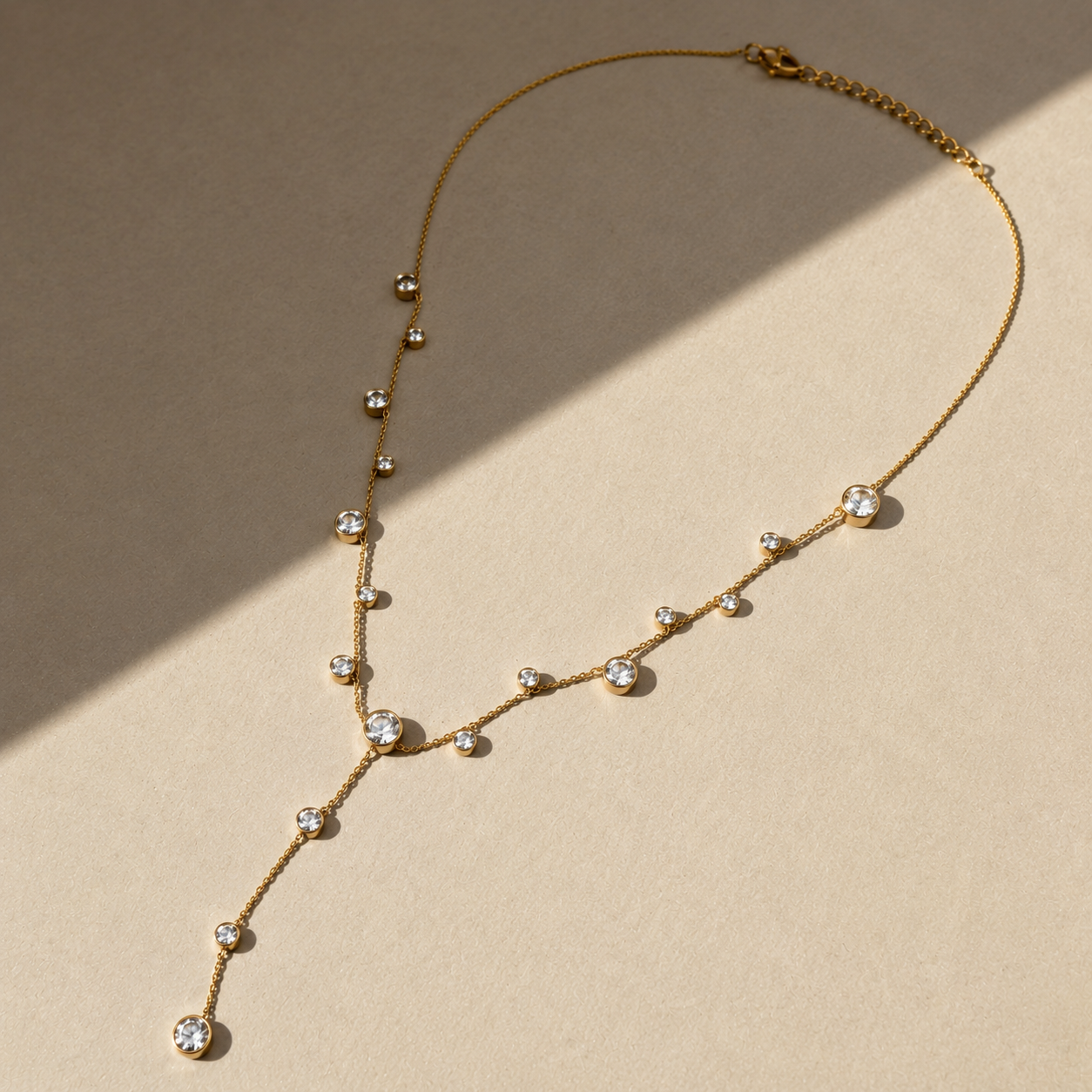 Delicate gold lariat necklace with small stones around 