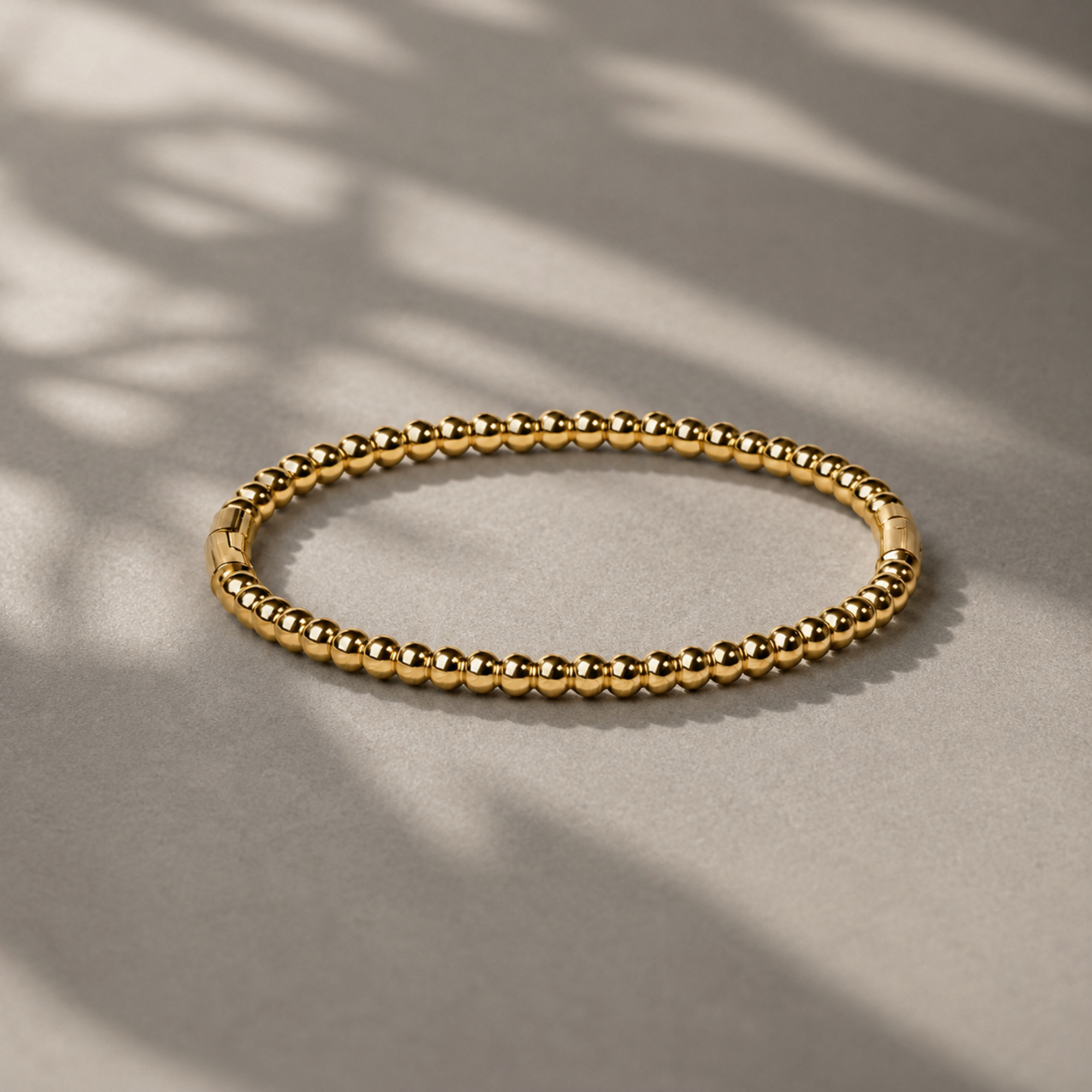 gold beaded cuff on grey background