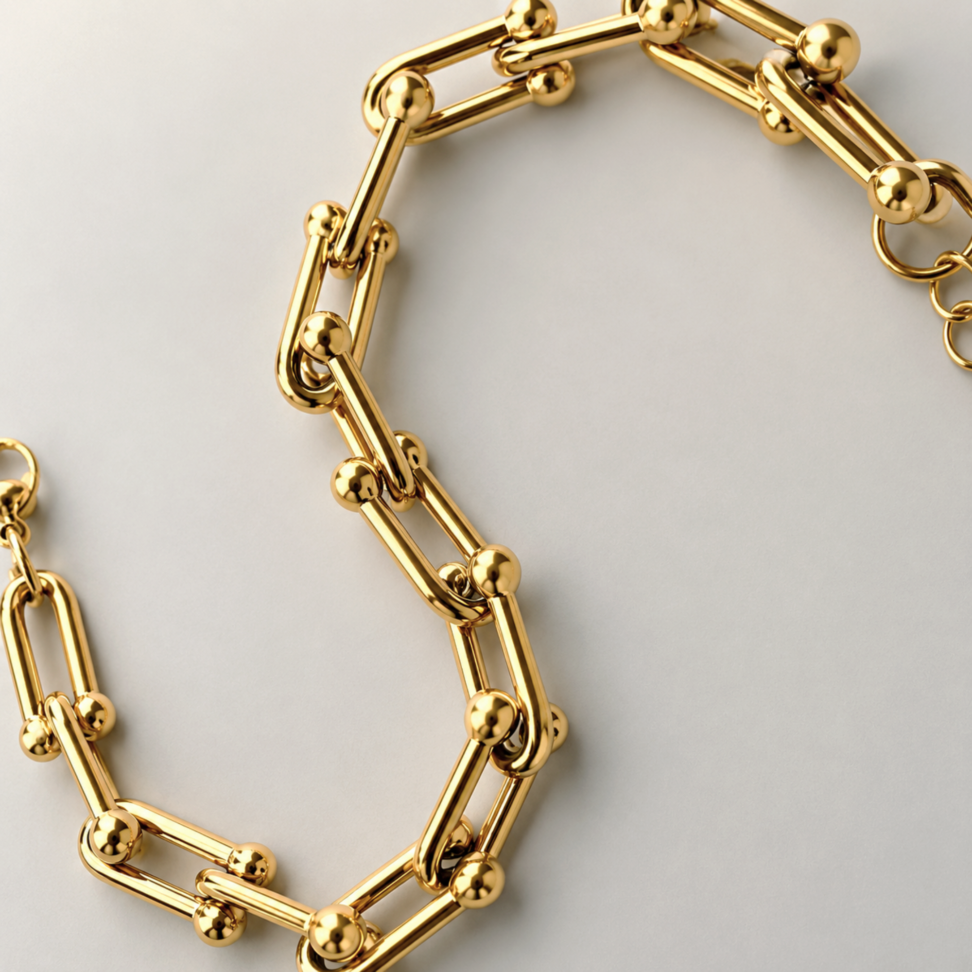 Gold hardware chain bracelet on a light gray background