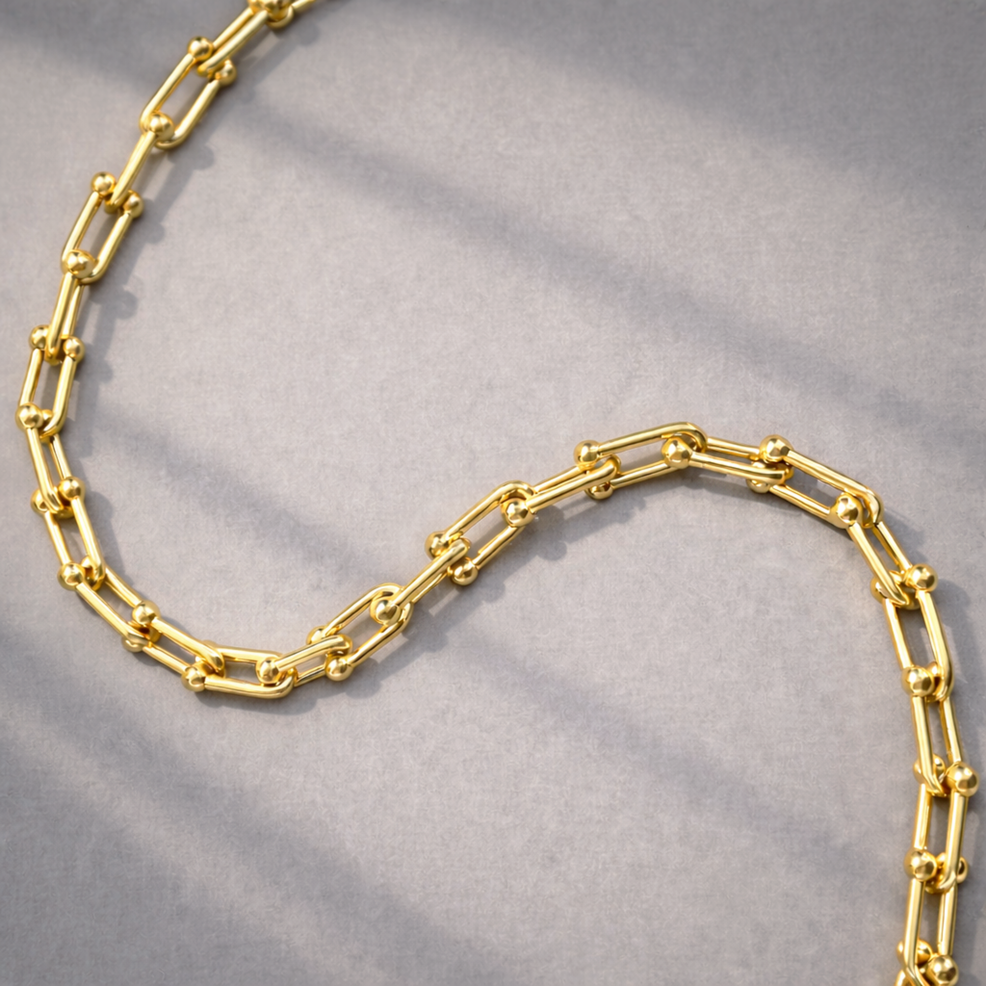 Gold hardware chain necklace on a gray background