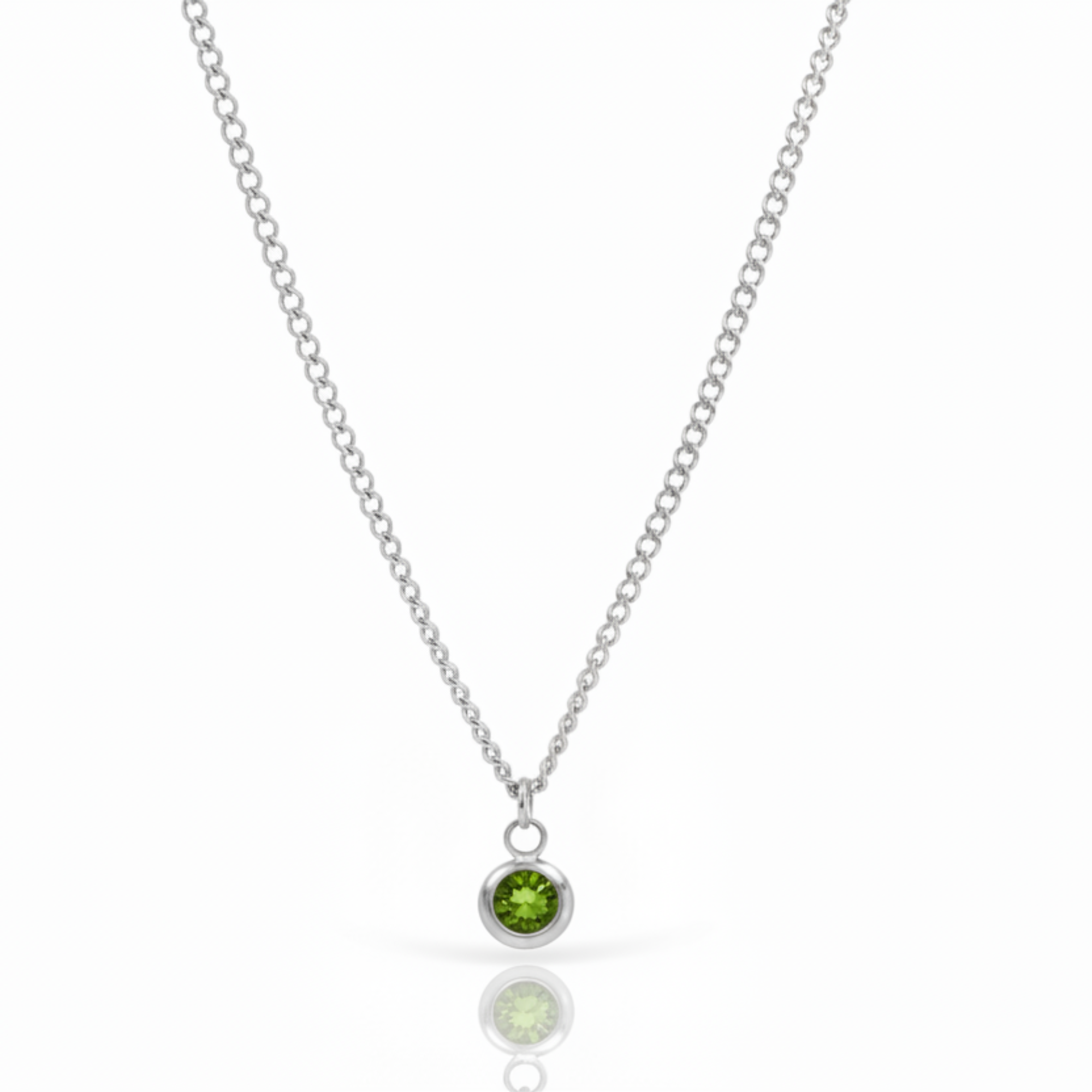A silver chain necklace with a small bezel-set green gemstone pendant, shown on a clean white background with a soft reflection below.