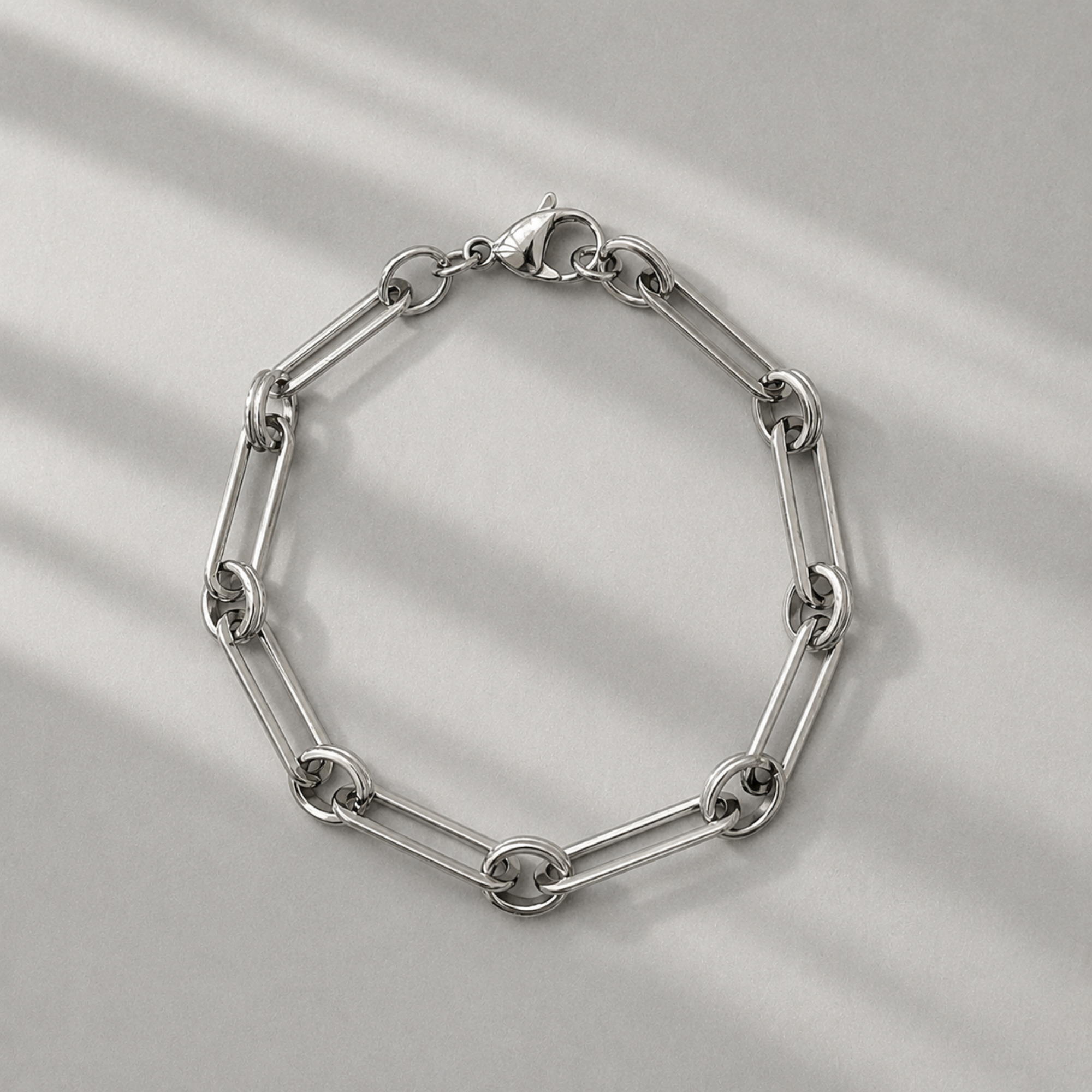 Silver paperclip chain bracelet on a light gray background