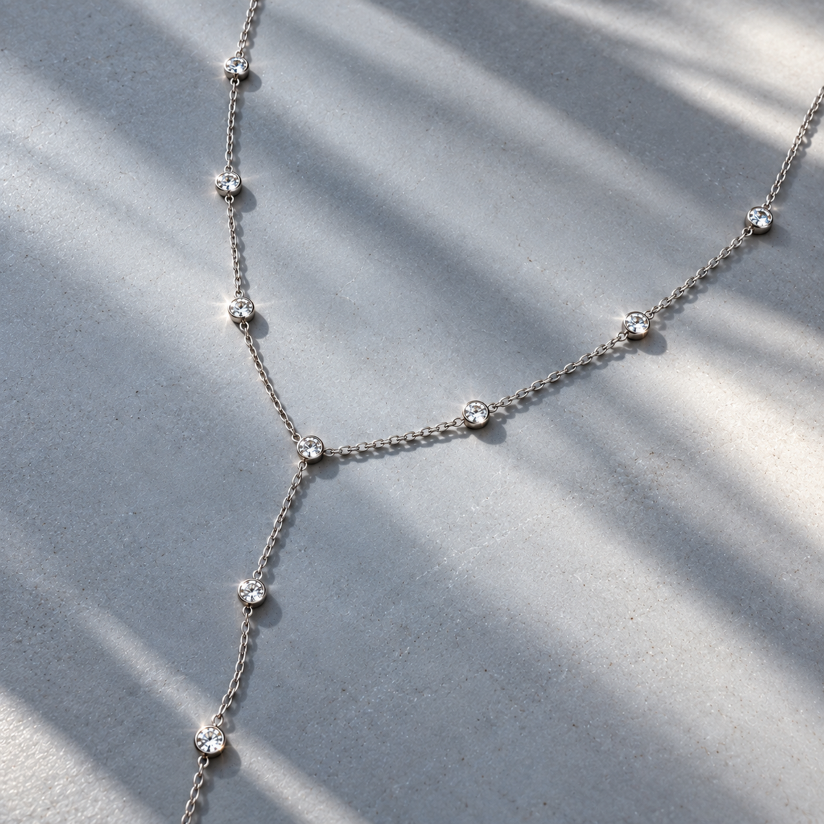 silver_diamond_station_lariet_necklace on blue background
