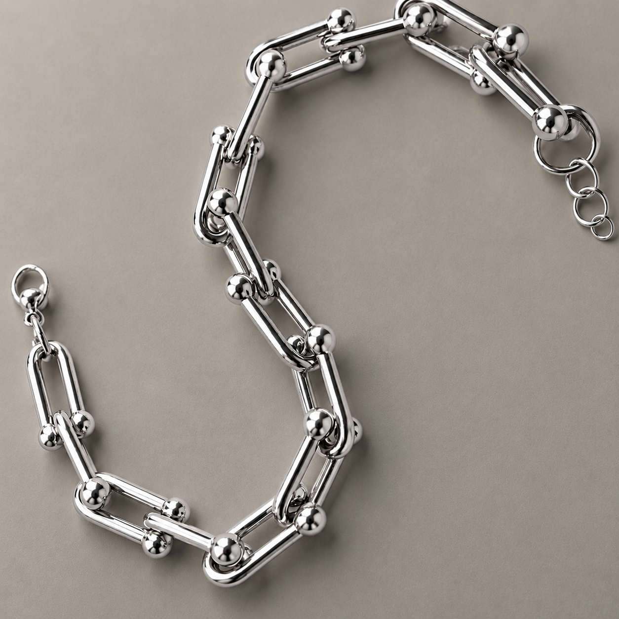 Silver hardware chain bracelet on a beige background