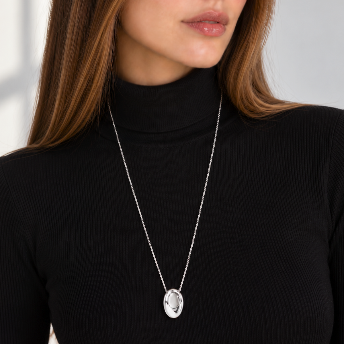 silver long oval pendant necklace on model 