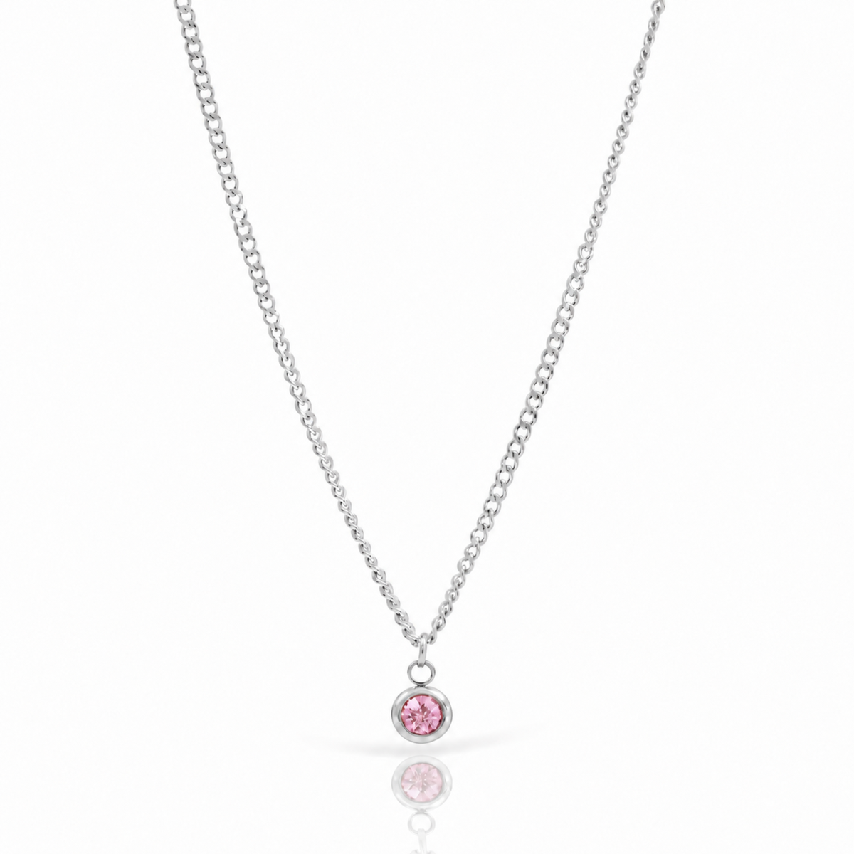 A silver chain necklace with a small round bezel pendant set with sparkling pink stones, displayed on a clean white background with a soft reflection below. Silver October birthstone necklace
