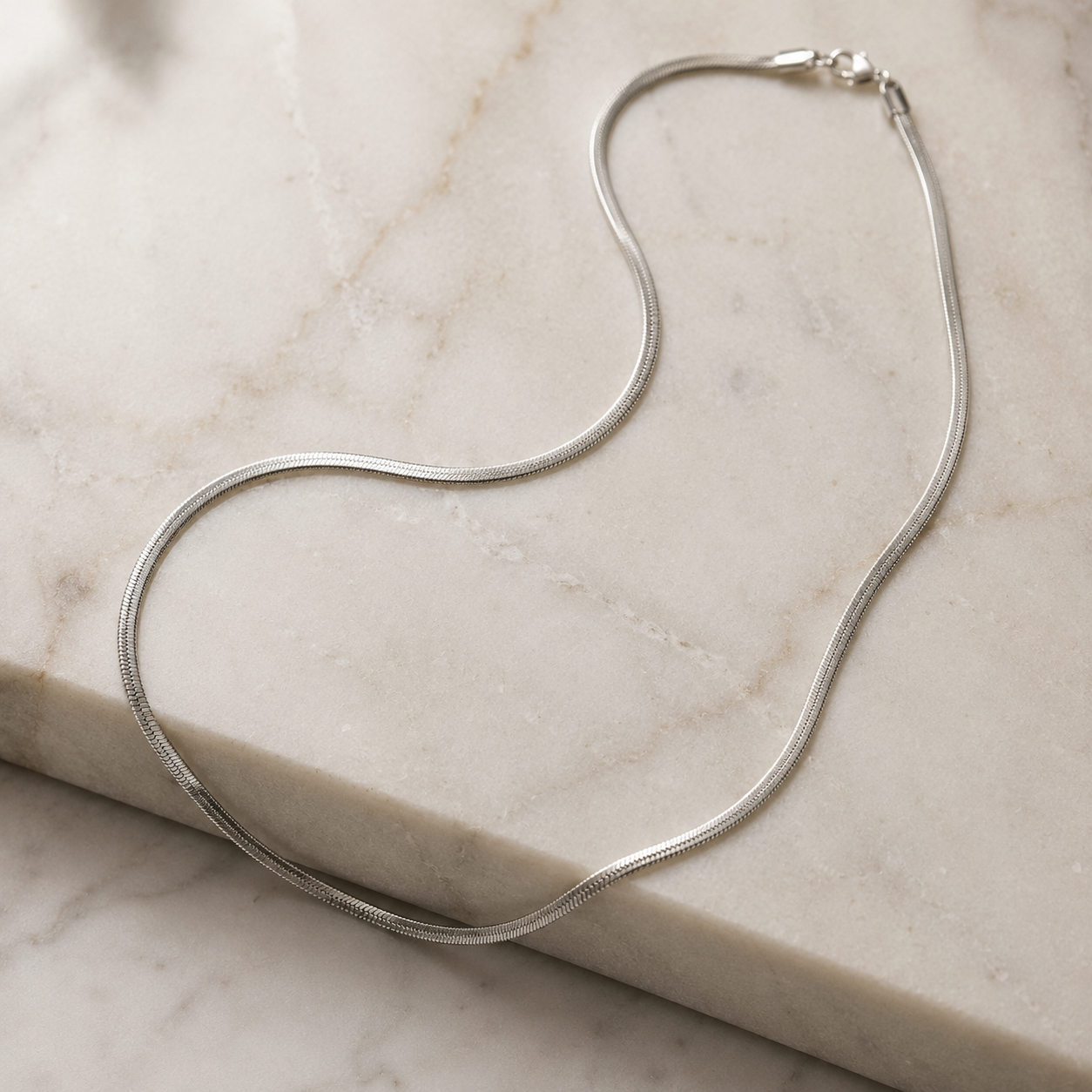 Silver necklace on a marble surface