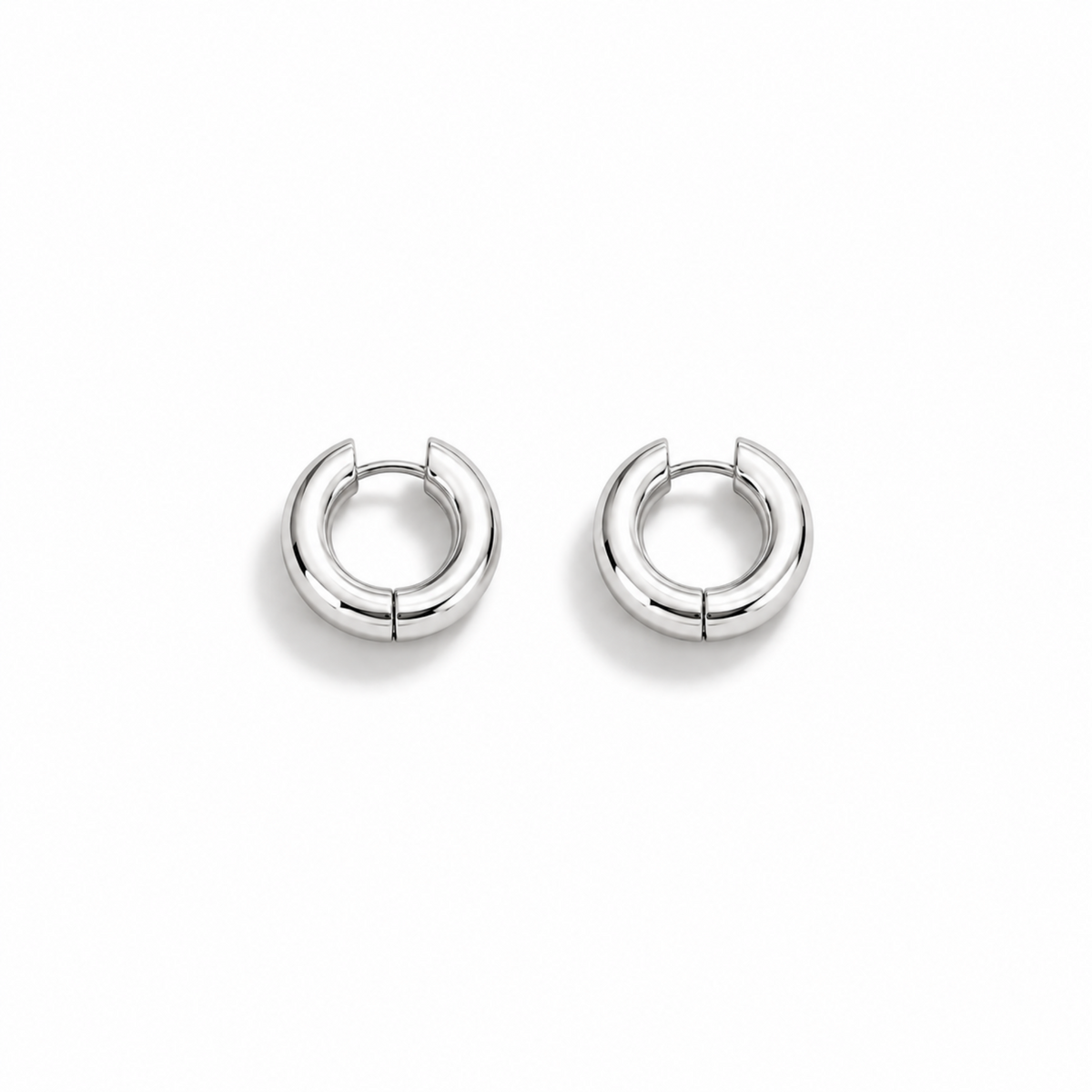 A pair of polished silver hoop earrings with a segmented, rounded design, displayed on a clean white background.