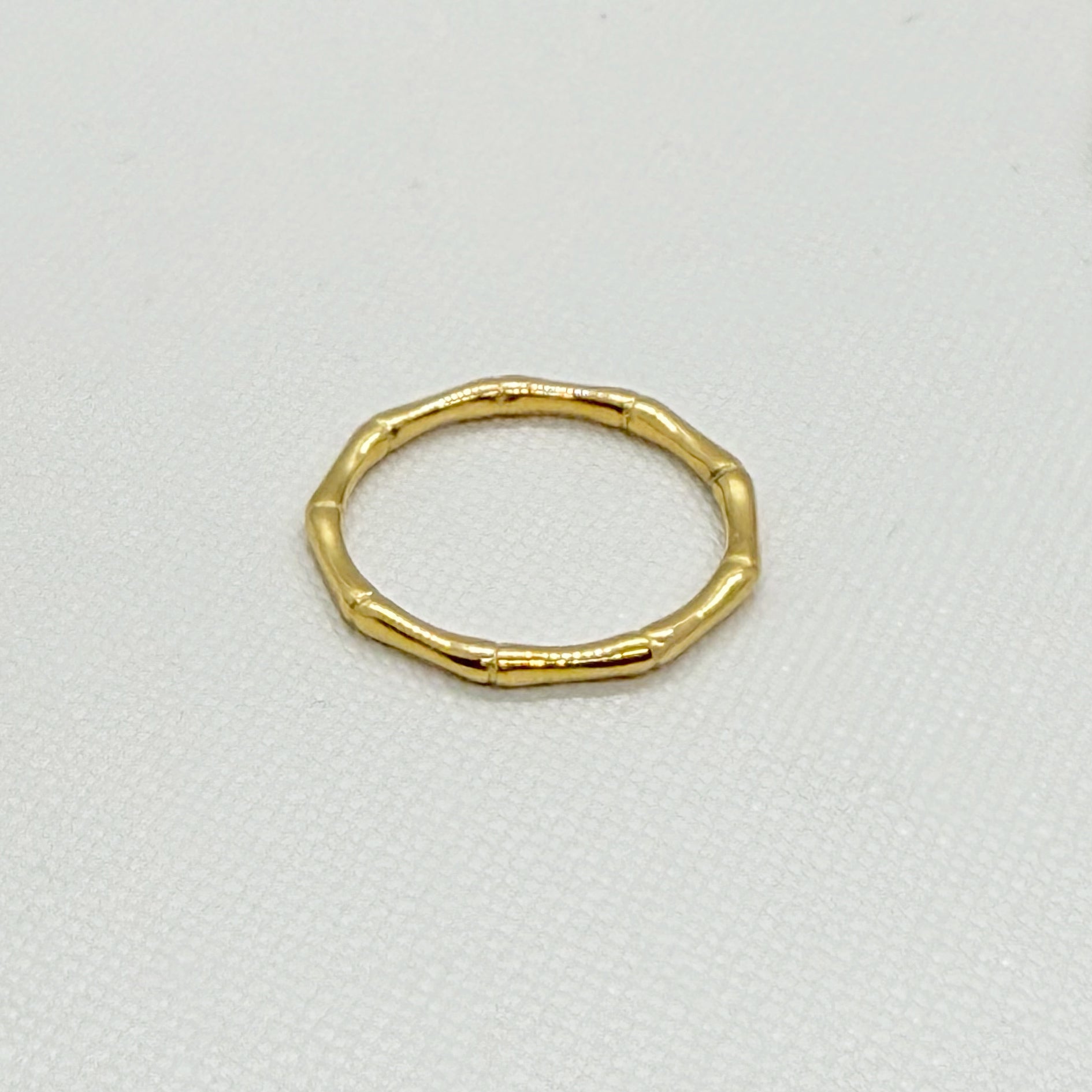 Gold high polish ring with a unique bamboo design on a white background