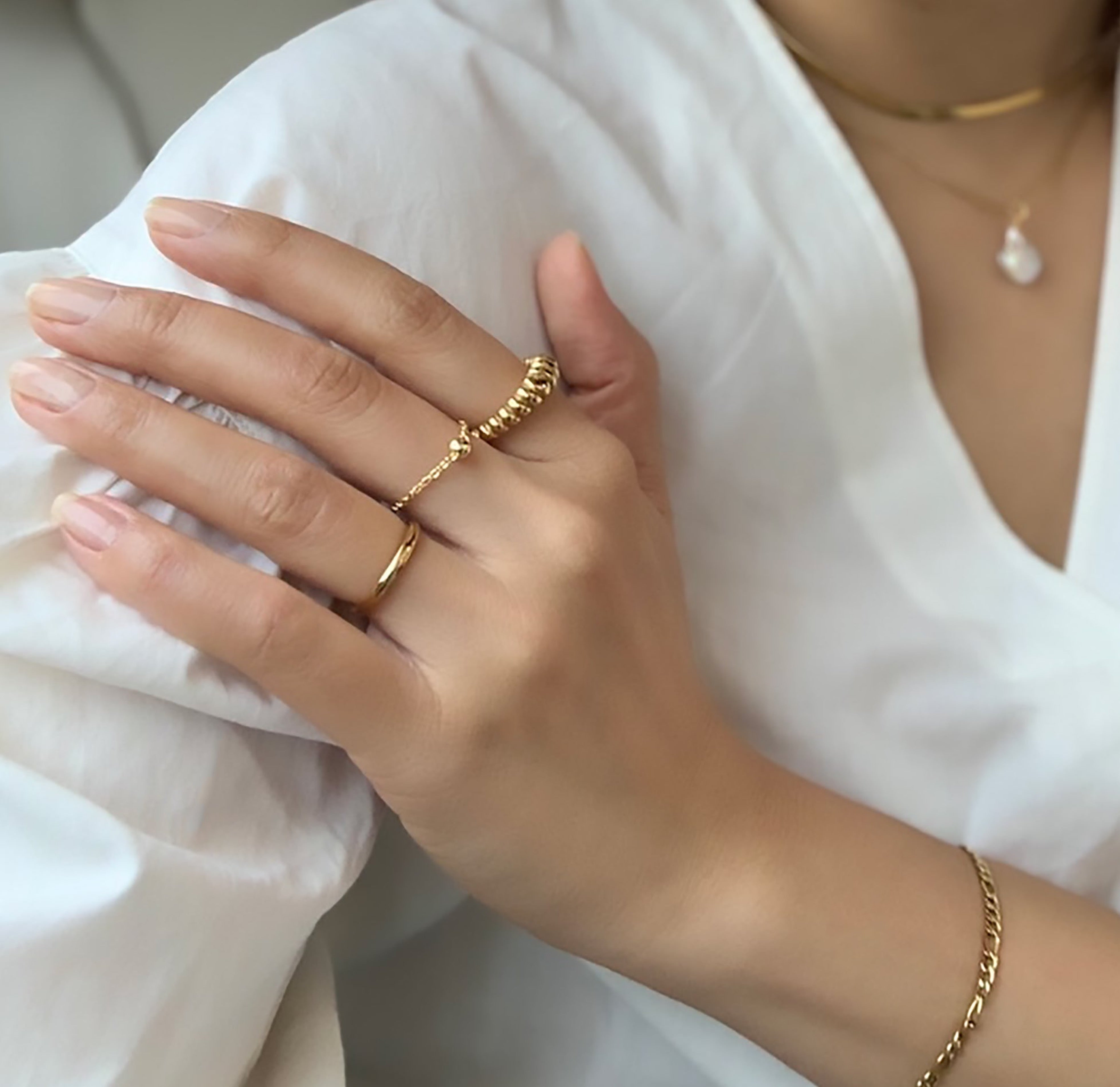 gold thin croissant ring worn with dainty gold Mila ring and think gold Didi ring band on model. waterproof jewelry